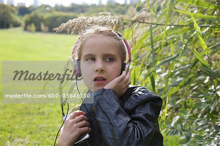 Young Girl Sitting Outside Listening to Music