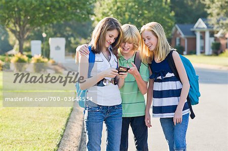 Gruppe von Freunden mit Handy in die Schule gehen