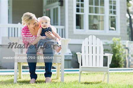 Mère et fils assis dans une chaise sur la pelouse