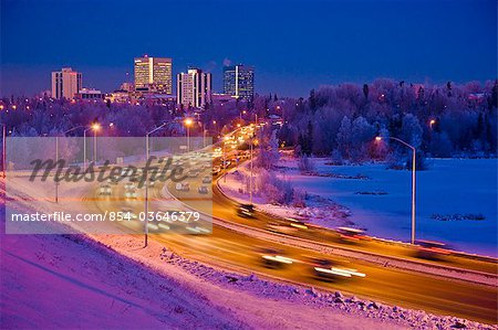 Twilight view of traffic on Minnesota Blvd. with downtown Anchorage in the background, Southcentral Alaska, Winter/n