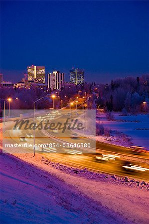 Vue Twilight de circulation sur le boulevard du Minnesota avec downtown Anchorage à l'arrière-plan, le centre-sud de l'Alaska, hiver/n