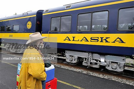 Whistle Stop passenger waits to board the Hurricane Turn train at the station in Talkeetna on an overcast day, Southcentral Alaska, Summer