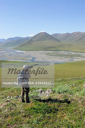 Woman photographing the tundra and scenery along the Kongakut River, ANWR, Arctic Alaska, Summer