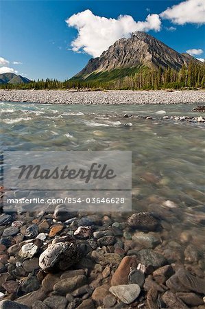 View of North Fork Koyukuk River flowing over a rocky gravel bar with Frigid Crags in the background,  Gates of the Arctic National Park & Preserve, Arctic Alaska, Summer