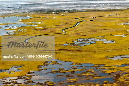 Aerial view of small cabins and other seasonal structures along the tidal flats across Cook Inlet  from Anchorage, Southcentral Alaska, Fall