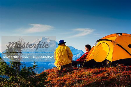 Ein Mann und eine Frau von ihrem Zelt in Peters Bergen mit Mt. McKinley in Alaska in den Hintergrund, der Denali State Park, South Central, Herbst/n