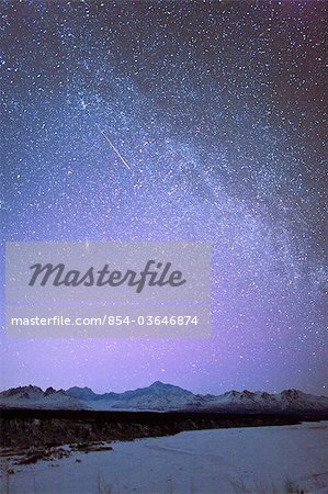 Night time view of Mt. McKinley with a star filled sky, the Milky Way, and a shooting star overhead, Denali State Park, Southcentral Alaska, Winter