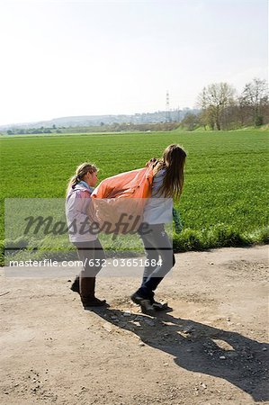 Girls carrying garbage bag together