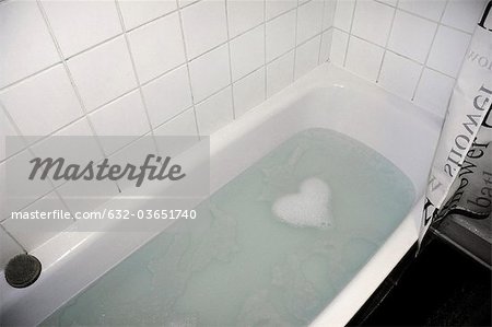Soap suds forming heart shape in bathtub