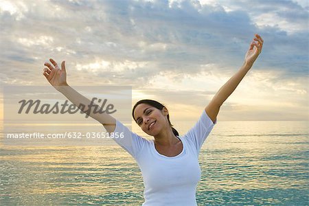 Woman stretching on the beach at sunset