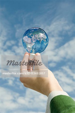 Person holding light bulb in front of sky