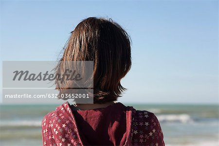 Femme contemplant l'océan, vue arrière