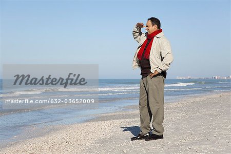 Man standing on beach looking at view