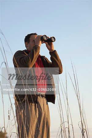 Man looking through binoculars