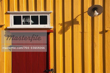 Maison jaune en bois avec porte rouge