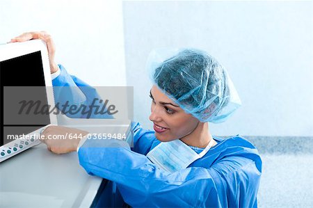 Surgeon adjusting monitor in operating room