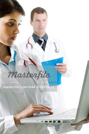 Médecin avec ordinateur portable et le médecin avec le dossier médical