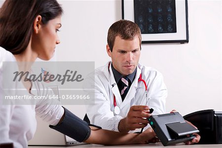 Doctor taking patient's blood pressure