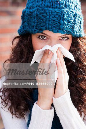 young woman wiping nose