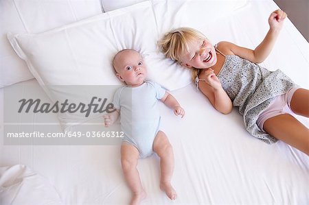 Mädchen mit ihrem kleinen Bruder im Bett