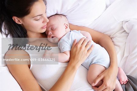 Frau und ihr Baby schläft im Bett