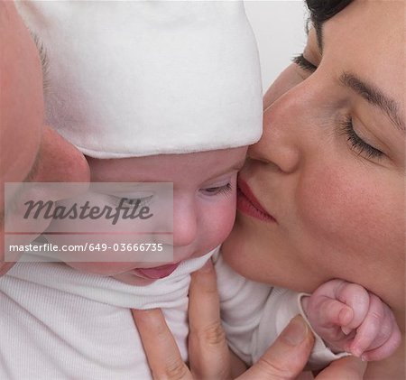 Parents kissing baby, gros plan