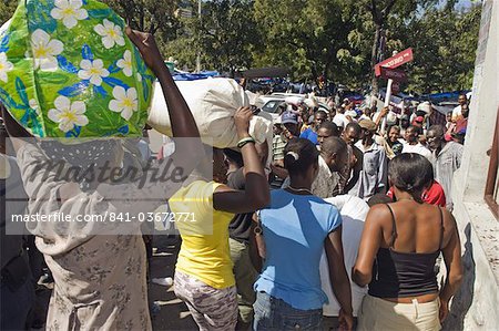 Femmes portant des sacs de riz à la distribution de vivres après le tremblement de terre de janvier 2010, Port au Prince (Haïti), Antilles, Caraïbes, Amérique centrale