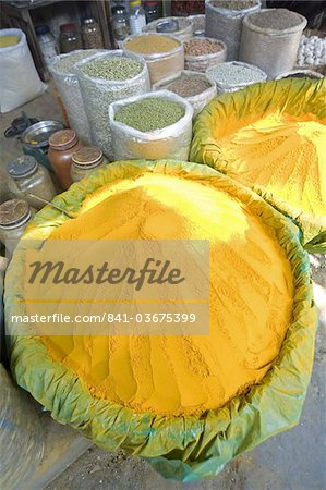 Spice market stall with large bowls of turmeric powder in early morning market on the banks of the Brahmaputra river, Guwahati, Assam, India, Asia