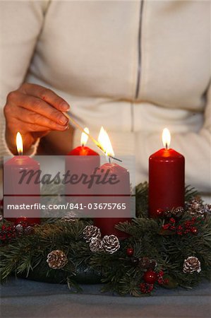 Woman lighting advent candles, Saint Nicolas de Veroce, Haute Savoie, France, Europe