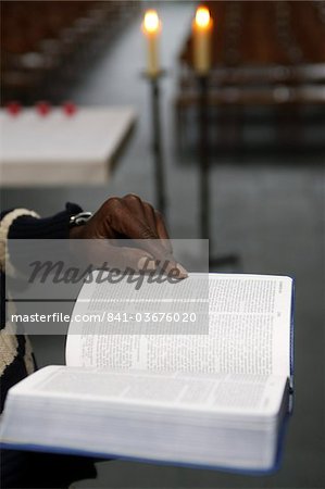 African man reading the Bible in a church, Paris, France, Europe