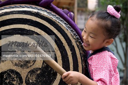 Ein kleines Mädchen, das immer in den Geist der Dinge mit der Taiko-Trommel Sanja Festival in Asakusa, Tokio, Japan, Asien