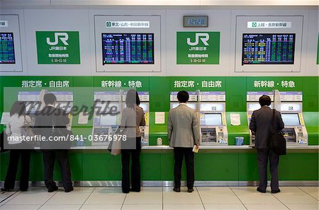 Passengers purchasing bullet train tickets from vending machines at the central JR (Japan Railway) station in Tokyo, Japan, Asia