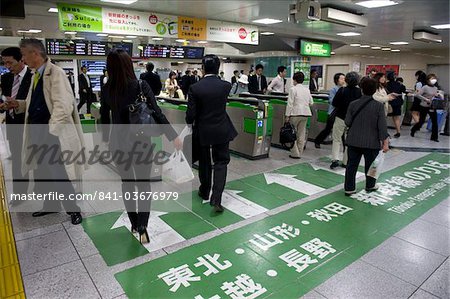 Passengers hurrying through automatic ticket wickets on their way to bullet train platforms at Tokyo Station, Japan, Asia