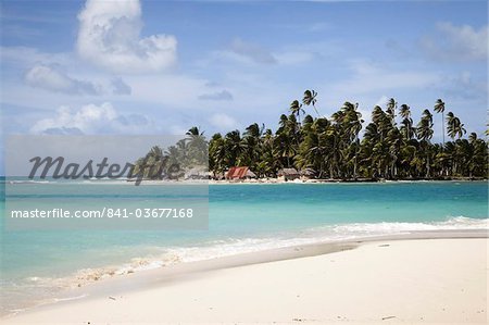 Palmiers et huttes sur l'île de Diablo à partir de la plage sur l'île de chien, îles de San Blas, Panama, l'Amérique centrale de chaume Palmiers et huttes sur l'île de Diablo à partir de la plage sur l'île de chien, îles de San Blas, Panama, l'Amérique centrale de chaume