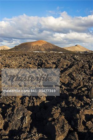 Irregular blocky lava (a'a) and cinder cones of the volcanic landscape of Timanfaya National Park, Lanzarote, Canary Islands, Spain, Atlantic Ocean, Europe