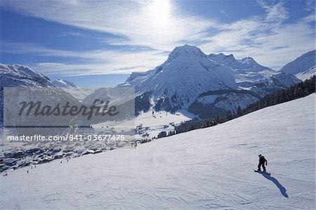 Snow-boarder sur piste à Lech près de St. Anton am Arlberg dans la neige de l'hiver, Alpes autrichiennes, Autriche, Europe