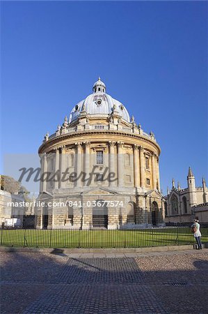 Étudiant se tient devant la Radcliffe Camera, Université d'Oxford, Oxford, Oxfordshire, Angleterre, Royaume-Uni, Europe