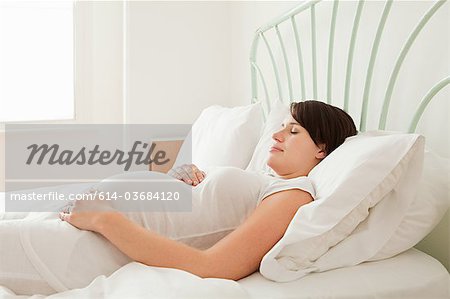 Femme enceinte endormie dans son lit