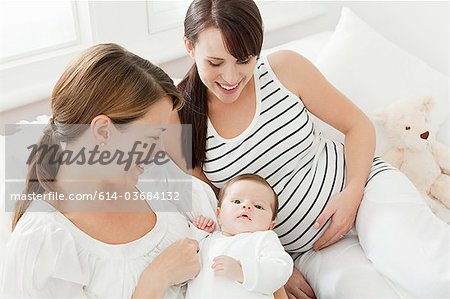 Mutter mit Baby-Mädchen und schwangere Freundin