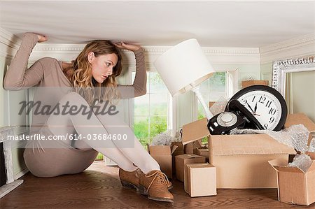 Junge Frau mit Box von Objekten im kleinen Raum