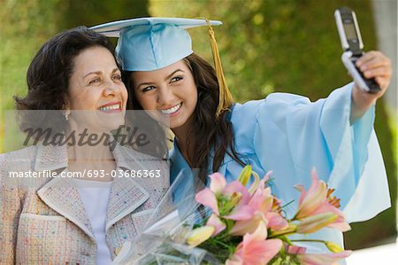 Études supérieures et grand-mère prise de photo avec le téléphone cellulaire à l'extérieur