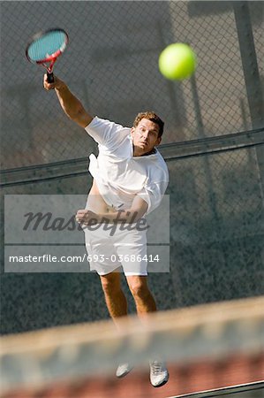 Man Serving Tennis Ball on tennis net