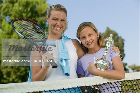 Mother and Daughter at Tennis Net with Trophy, portrait, low angle view