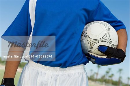 Soccer goalkeeper (13-17) holding ball, mid section