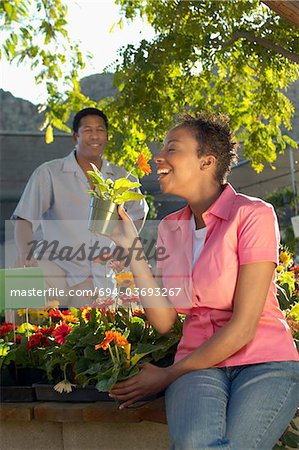 Woman smelling flowers at plant nursery
