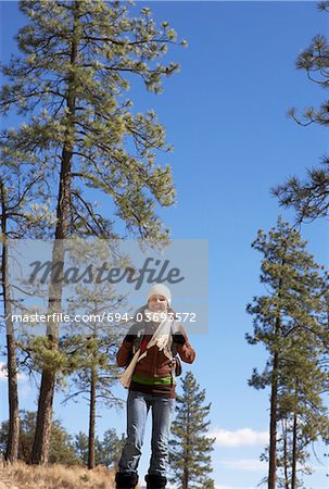 Young Woman walking through trees, low angle view.