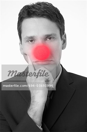 Homme d'affaires avec la tête dans le portrait de mains, porter des nez de Clown,