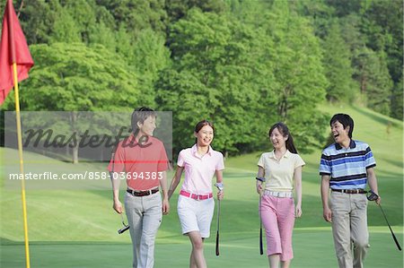 Hommes et femmes marchant sur le parcours de Golf