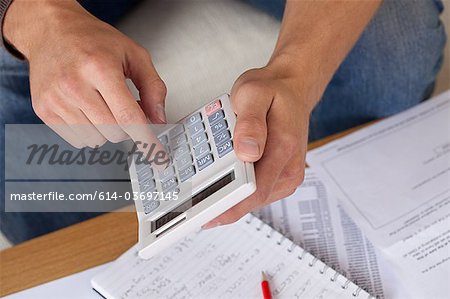 Junger Mann mit Kalkulator