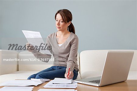 Junge Frau mit Papierkram mit laptop